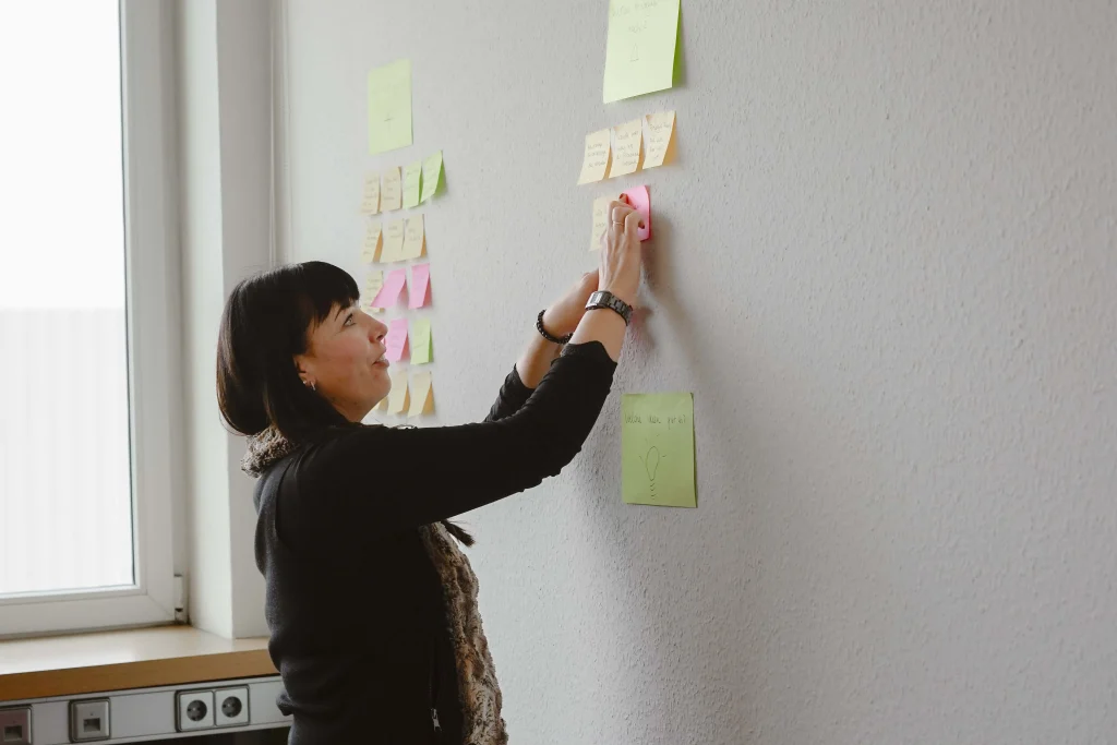 Personalreferentin klebt Post-It an die Wand